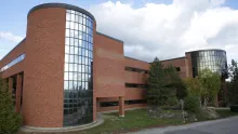 Exterior of the J.N. Desmarais Library. Red brick two story building, with round turrets at each corner.